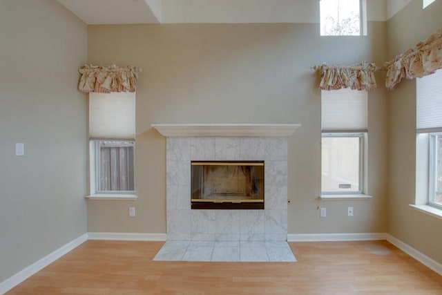 unfurnished living room featuring a tile fireplace and light wood-type flooring