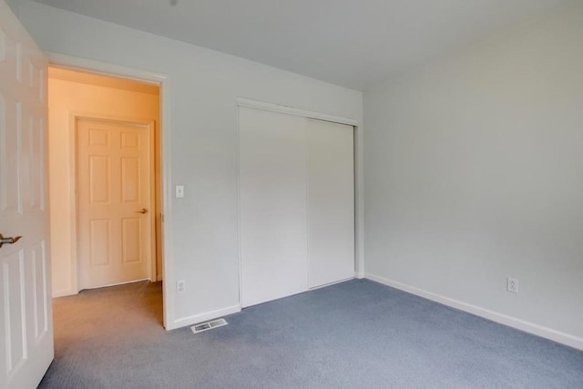 unfurnished bedroom featuring carpet flooring and a closet