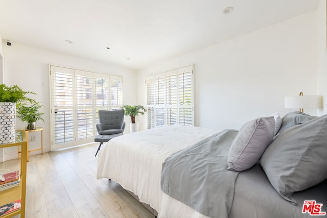 bedroom with access to outside and light wood-type flooring