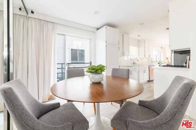 dining space with sink and light hardwood / wood-style floors