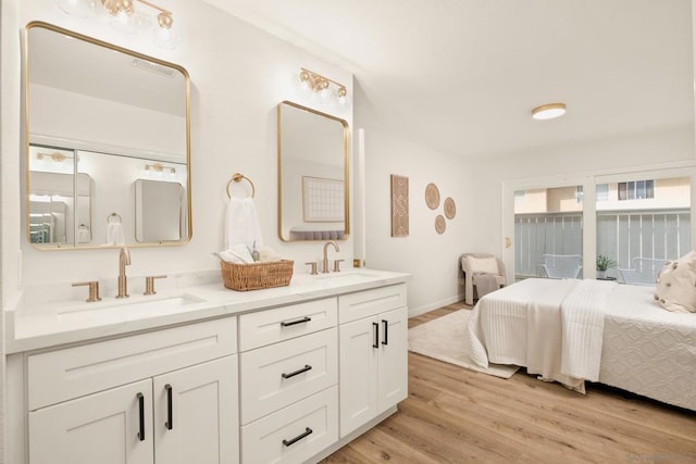 bedroom featuring access to exterior, sink, and light wood-type flooring