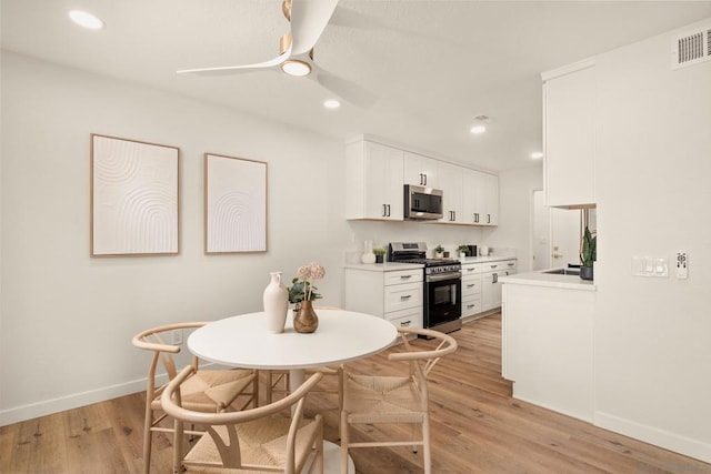 dining area with ceiling fan and light wood-type flooring