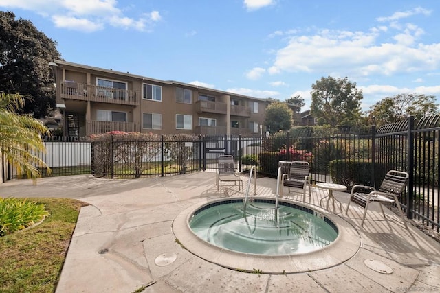 view of swimming pool featuring a hot tub and a patio