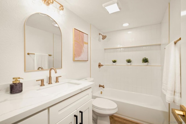 full bathroom with vanity, tiled shower / bath combo, wood-type flooring, and toilet