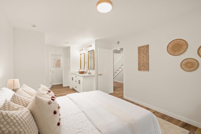 bedroom featuring sink and light hardwood / wood-style flooring