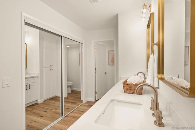 bathroom featuring vanity, toilet, and hardwood / wood-style floors