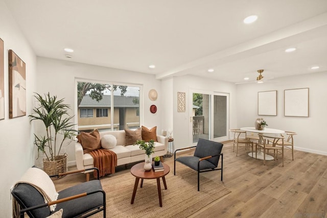 living room featuring beamed ceiling and light wood-type flooring