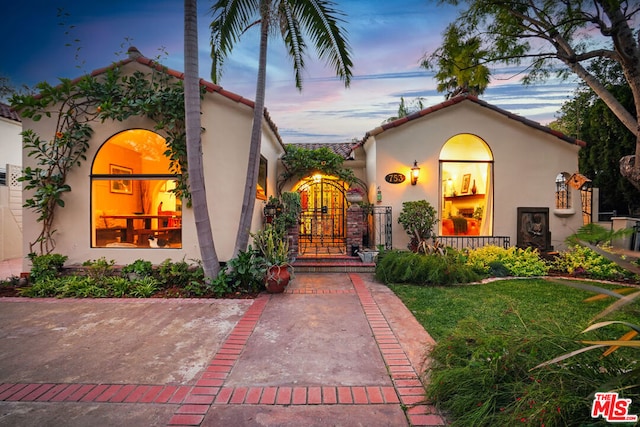 mediterranean / spanish house featuring a lawn