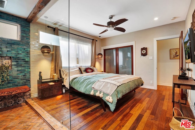 bedroom featuring ceiling fan, wood-type flooring, and beam ceiling