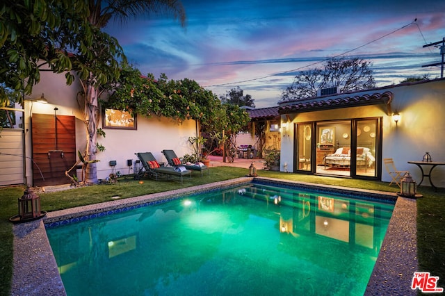 pool at dusk with a yard