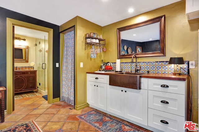 bathroom with vanity, an enclosed shower, tasteful backsplash, and tile patterned floors