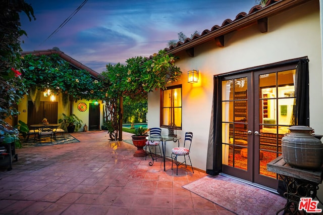 patio terrace at dusk featuring french doors