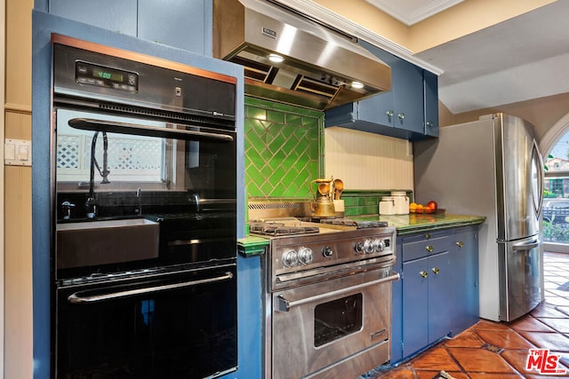 kitchen with blue cabinetry, appliances with stainless steel finishes, range hood, tasteful backsplash, and dark tile patterned flooring