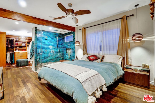 bedroom featuring ceiling fan, wood-type flooring, and beam ceiling