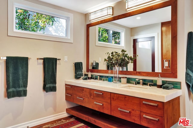 bathroom with vanity, backsplash, and plenty of natural light