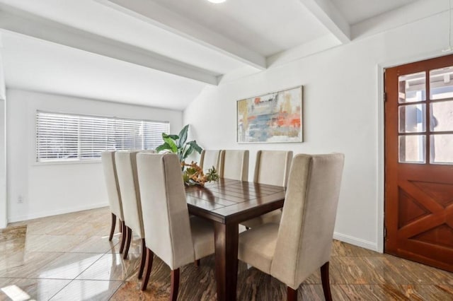 dining area featuring vaulted ceiling with beams