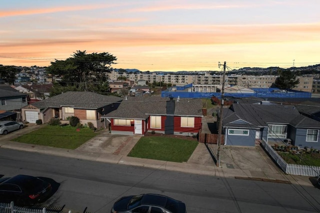 view of front of home with a garage and a lawn