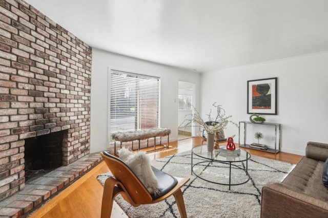 living room with hardwood / wood-style floors and a brick fireplace