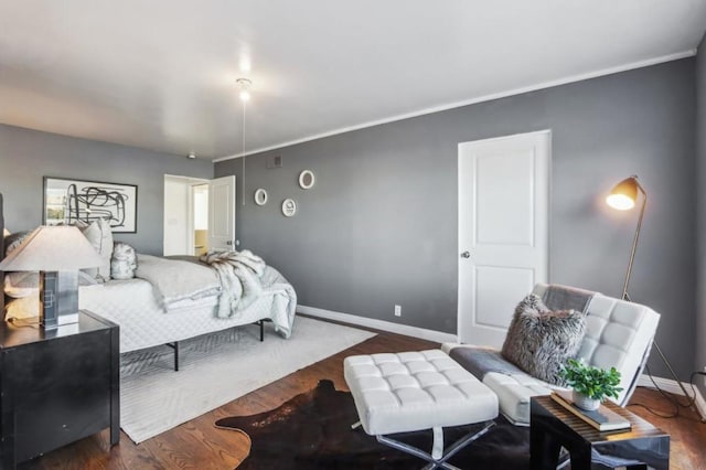 bedroom featuring ornamental molding and dark hardwood / wood-style floors