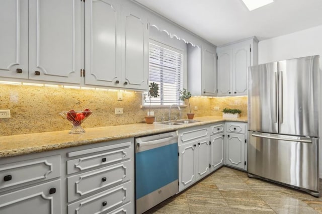 kitchen with sink, backsplash, white cabinets, and appliances with stainless steel finishes