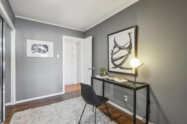 home office with ornamental molding and dark hardwood / wood-style flooring