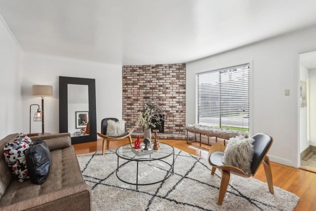 living room with a brick fireplace and light hardwood / wood-style flooring