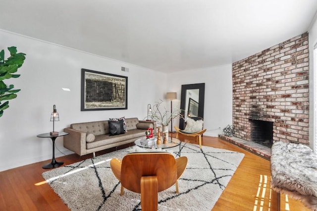 living room with hardwood / wood-style floors and a brick fireplace