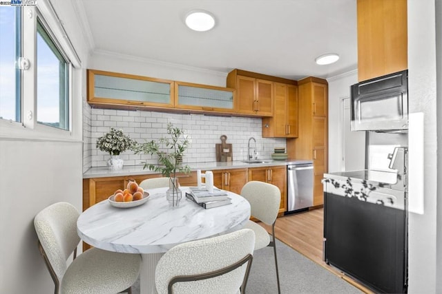 kitchen featuring sink, crown molding, tasteful backsplash, light hardwood / wood-style flooring, and stainless steel dishwasher