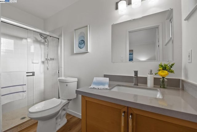 bathroom with walk in shower, vanity, toilet, and hardwood / wood-style flooring