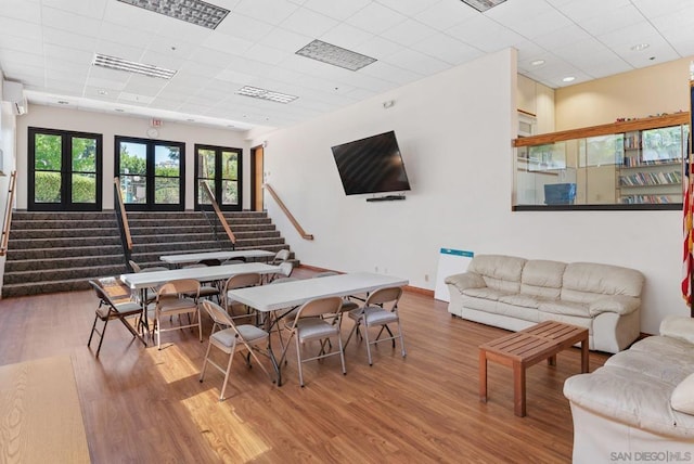 living room with wood-type flooring and a paneled ceiling