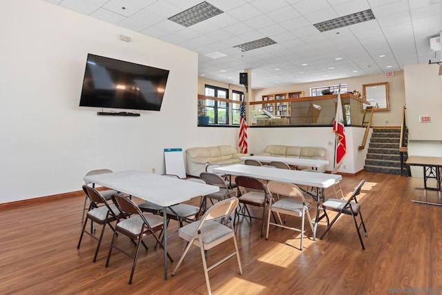 dining space with wood-type flooring and a paneled ceiling