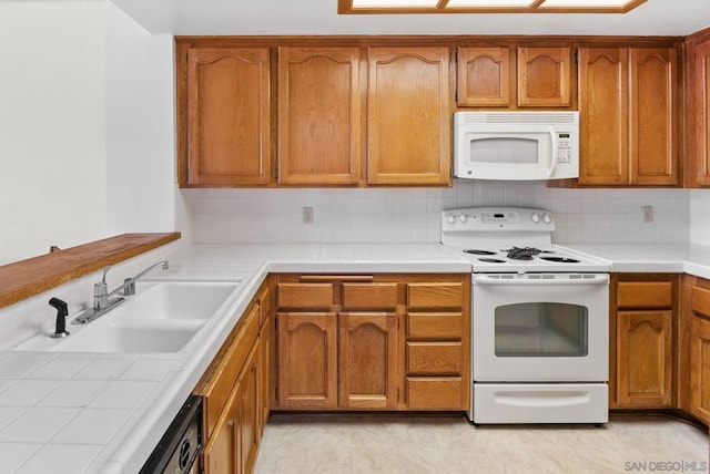 kitchen with tasteful backsplash, sink, white appliances, and tile counters