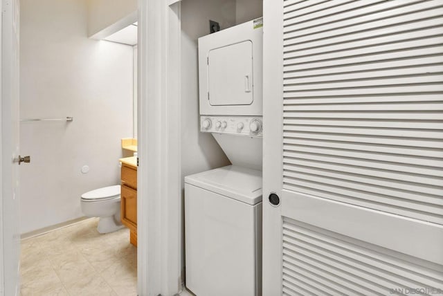 clothes washing area with stacked washer / dryer and light tile patterned floors