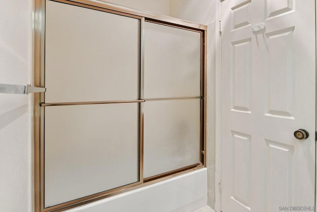 bathroom with shower / bath combination with glass door