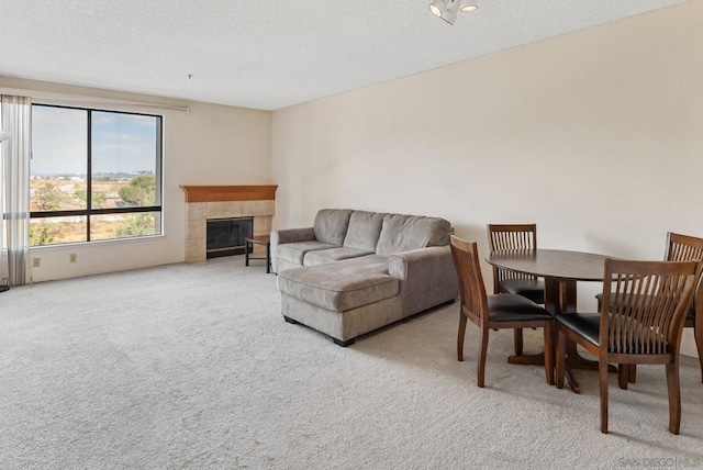 carpeted living room with a fireplace and a textured ceiling