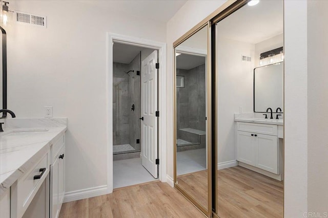 bathroom with vanity, hardwood / wood-style flooring, and a shower with shower door