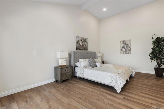 bedroom featuring wood-type flooring and lofted ceiling with beams