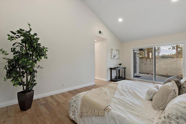 bedroom featuring hardwood / wood-style flooring, high vaulted ceiling, and access to outside