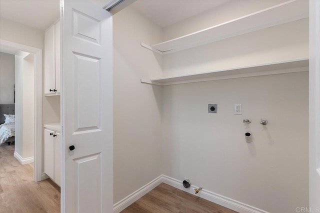 washroom featuring hookup for a gas dryer, hookup for a washing machine, light hardwood / wood-style floors, and electric dryer hookup