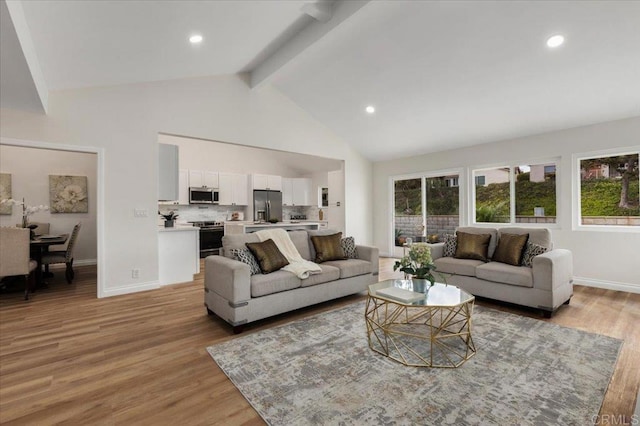 living room with high vaulted ceiling, beamed ceiling, and light wood-type flooring