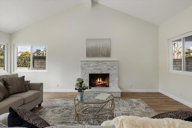 living room featuring beam ceiling, a stone fireplace, high vaulted ceiling, and dark hardwood / wood-style floors