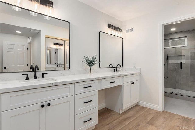 bathroom with walk in shower, vanity, and hardwood / wood-style floors