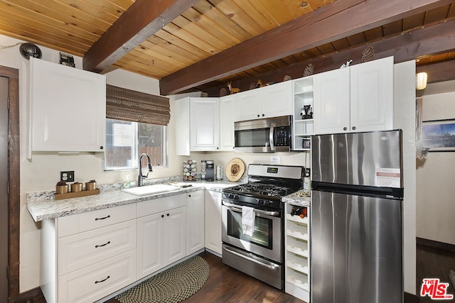 kitchen featuring sink, stainless steel appliances, light stone countertops, white cabinets, and beamed ceiling