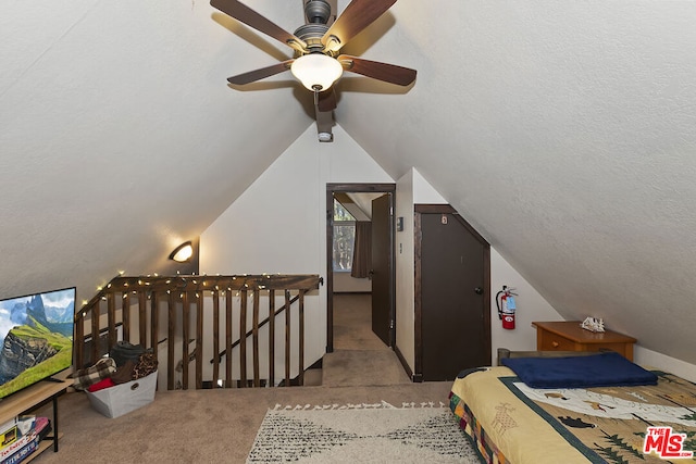 carpeted bedroom featuring ceiling fan, lofted ceiling, and a textured ceiling