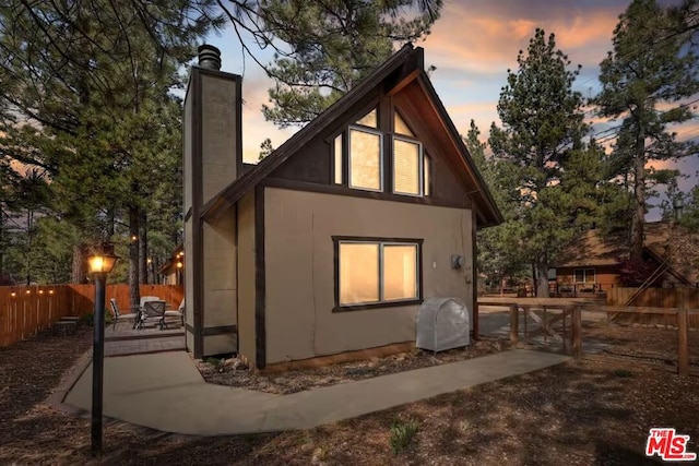 property exterior at dusk featuring a patio