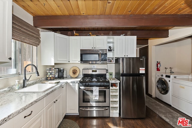 kitchen with appliances with stainless steel finishes, sink, white cabinets, light stone counters, and independent washer and dryer