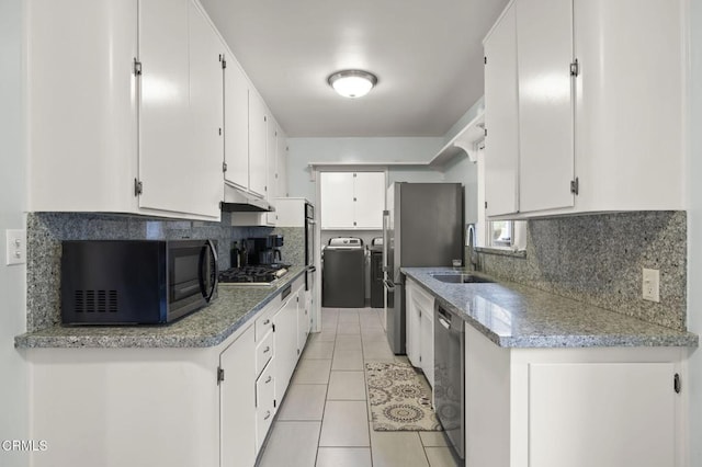 kitchen with stainless steel appliances, separate washer and dryer, sink, and white cabinets