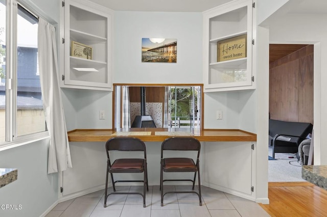 kitchen with white cabinetry, a breakfast bar area, and light tile patterned flooring