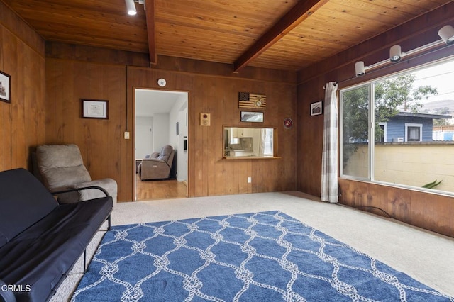 unfurnished room with beamed ceiling, carpet, wooden ceiling, and wood walls