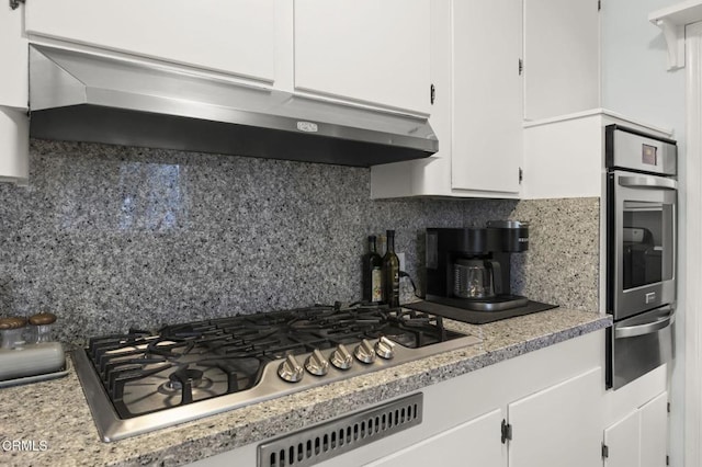 kitchen featuring white cabinetry, backsplash, and stainless steel appliances